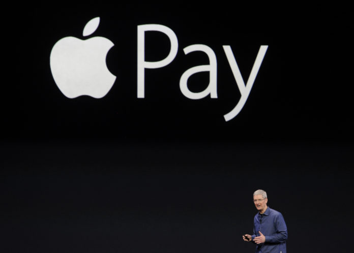Tim Cook, chief executive officer of Apple Inc., unveils Apple Pay during a product announcement at Flint Center in Cupertino, California, U.S., on Tuesday, Sept. 9, 2014. Apple Inc. unveiled redesigned iPhones with bigger screens, overhauling its top-selling product in an event that gives the clearest sign yet of the company's product direction under Cook. Photographer: David Paul Morris/Bloomberg *** Local Caption *** Tim Cook