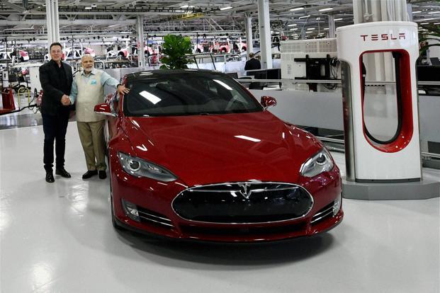 Tesla Motors CEO Elon Musk with Indian Prime Minister Narendra Modi standing next to a Tesla EV